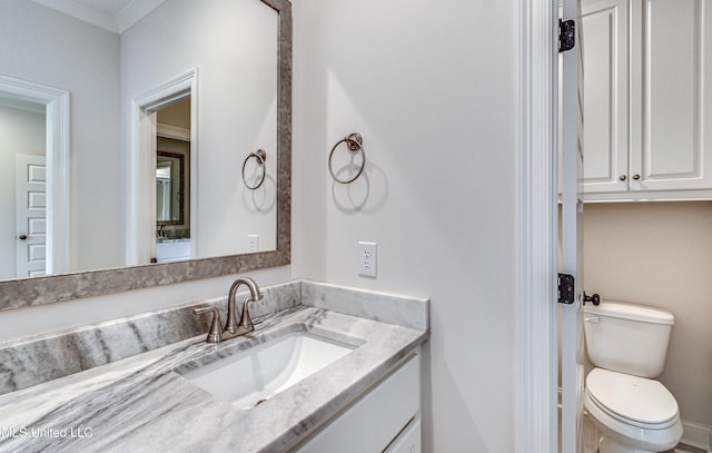 bathroom featuring vanity, toilet, and crown molding