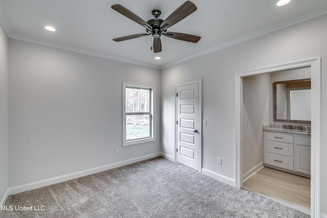 unfurnished bedroom with ceiling fan, crown molding, and light colored carpet