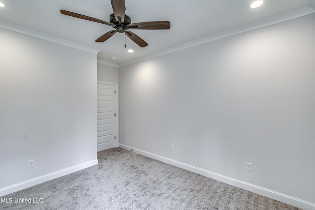 carpeted spare room with ceiling fan and ornamental molding