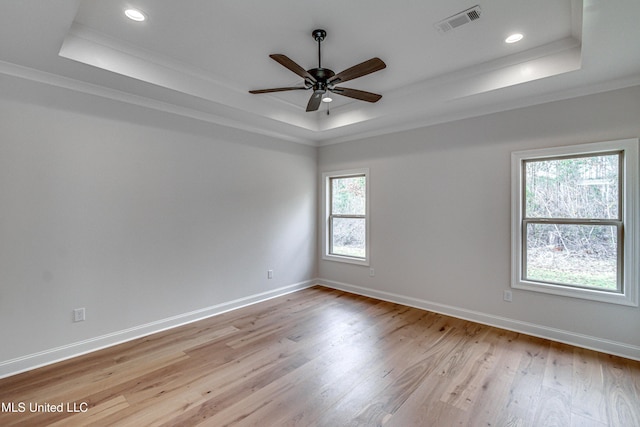 unfurnished room with a tray ceiling, light hardwood / wood-style flooring, ceiling fan, and crown molding