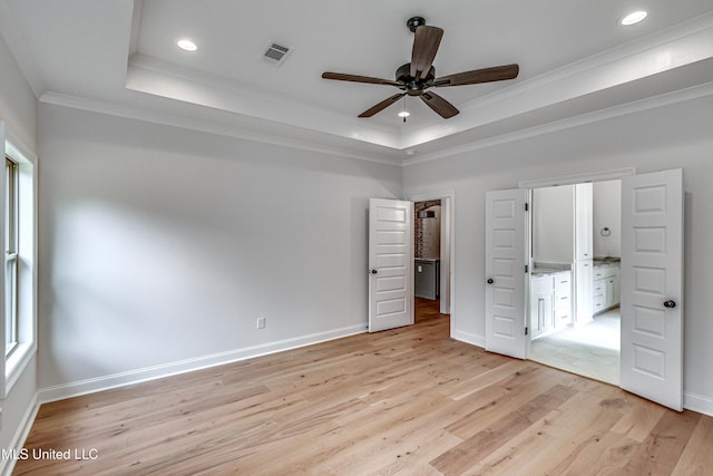 unfurnished bedroom with ceiling fan, a raised ceiling, light hardwood / wood-style flooring, crown molding, and multiple windows