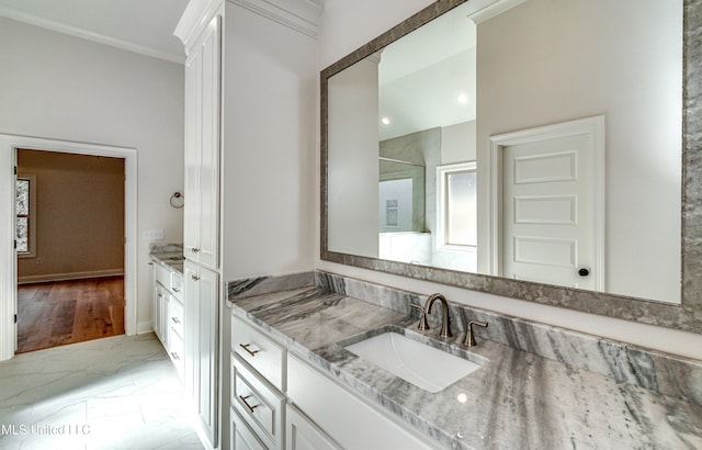 bathroom with hardwood / wood-style floors, vanity, and ornamental molding