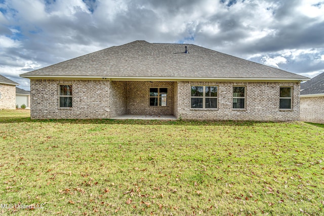 back of property featuring a lawn and a patio