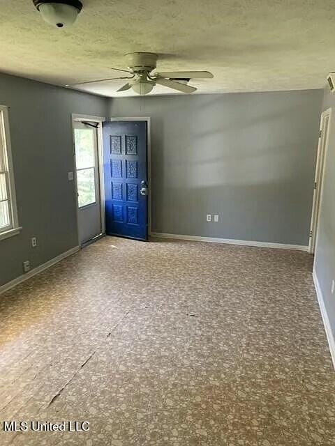 interior space with ceiling fan and a textured ceiling