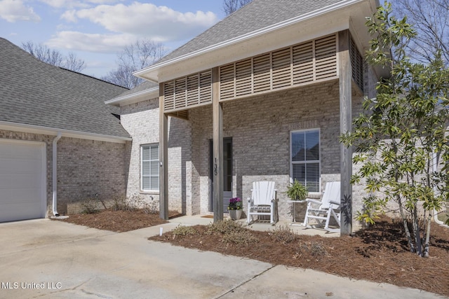 view of front of property with brick siding, roof with shingles, and driveway