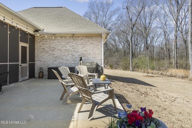 view of patio with a sunroom and a grill