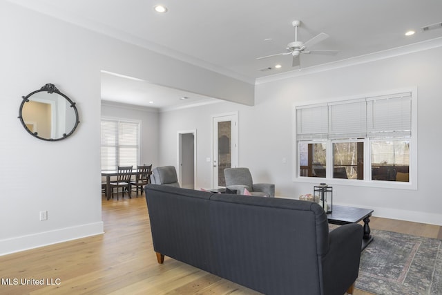 living room featuring ceiling fan, crown molding, visible vents, and light wood-type flooring