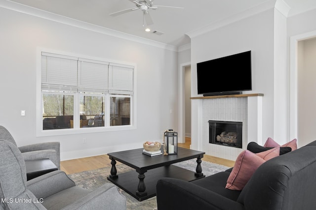 living room with ornamental molding, recessed lighting, a fireplace, wood finished floors, and a ceiling fan