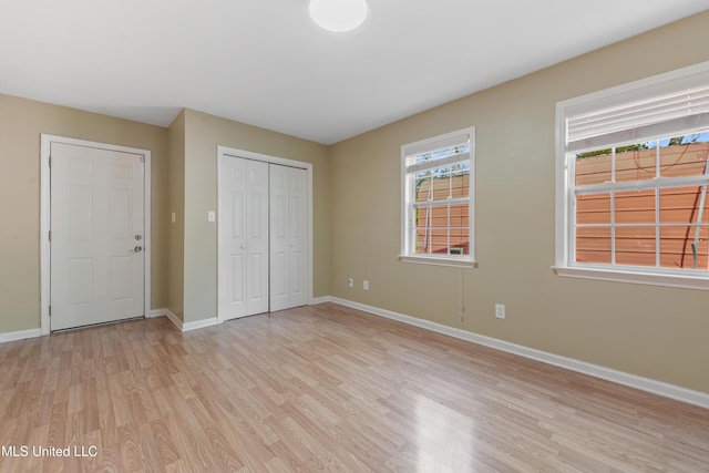 unfurnished bedroom featuring a closet and light wood-type flooring