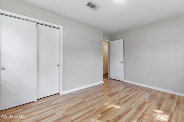 unfurnished bedroom featuring light hardwood / wood-style floors and a closet