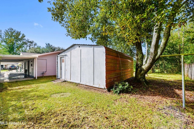 view of outdoor structure featuring a lawn and a carport