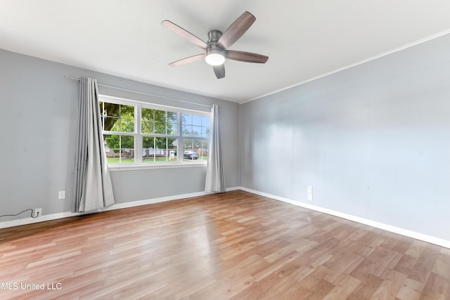 empty room featuring ceiling fan, light wood-type flooring, and ornamental molding