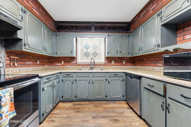 kitchen with gray cabinetry, ventilation hood, sink, light hardwood / wood-style flooring, and appliances with stainless steel finishes