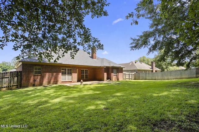 452 Pecan Cir, Brandon, MS 39042 - back of property with a fenced backyard, brick siding, a patio, and a chimney