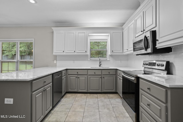 452 Pecan Cir, Brandon, MS 39042 - kitchen with gray cabinets, appliances with stainless steel finishes, a peninsula, backsplash, and light tile patterned floors