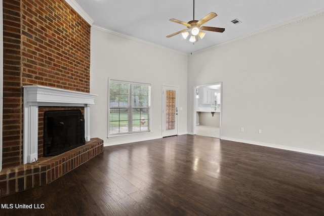 452 Pecan Cir, Brandon, MS 39042 - unfurnished living room with ceiling fan, wood finished floors, a brick fireplace, a high ceiling, and crown molding