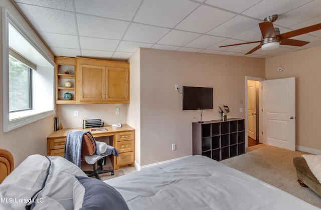 carpeted bedroom with a drop ceiling and ceiling fan