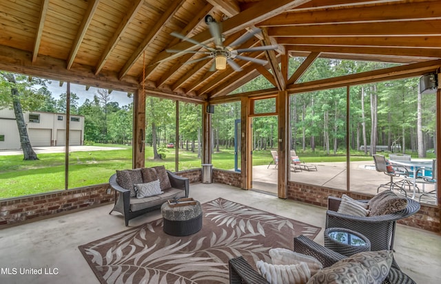 unfurnished sunroom with ceiling fan, vaulted ceiling with beams, and plenty of natural light