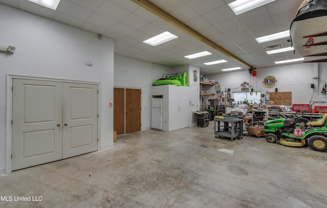 904 Northwood Cir, Brandon, MS 39047 - garage with a workshop area, visible vents, and freestanding refrigerator