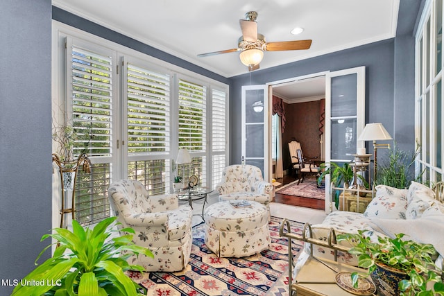 sitting room with ornamental molding, wood-type flooring, and ceiling fan