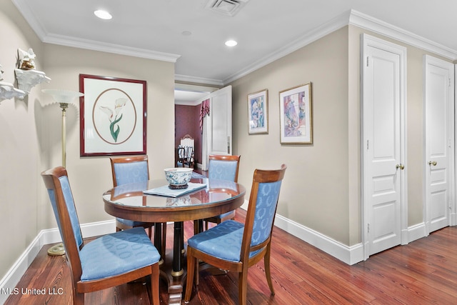 dining area with crown molding and dark wood-type flooring