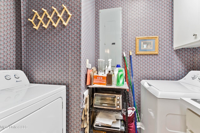 laundry room with electric panel, washer and clothes dryer, and cabinets