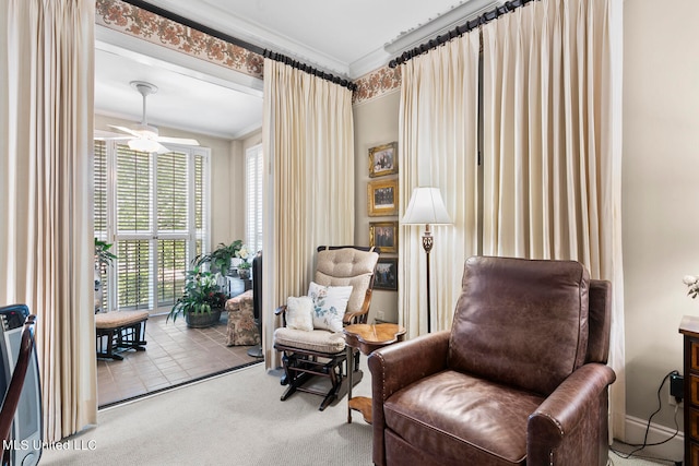 sitting room featuring ornamental molding, light colored carpet, and ceiling fan