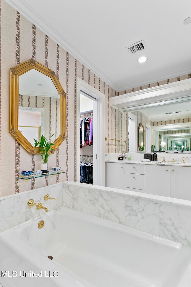 bathroom featuring vanity, a tub to relax in, and ornamental molding