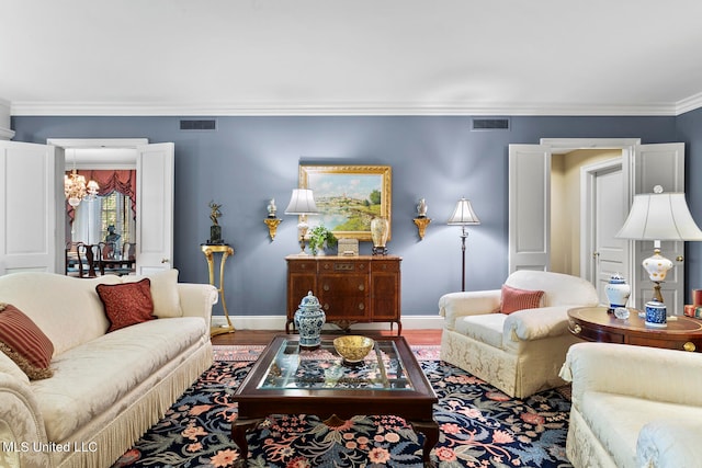 living room with crown molding, hardwood / wood-style floors, and a chandelier