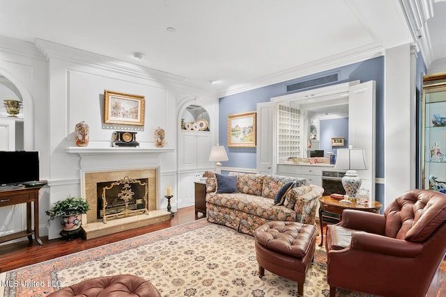 living room featuring crown molding, a premium fireplace, and dark hardwood / wood-style flooring