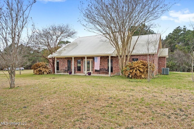 view of front of home featuring a front yard, central AC, and brick siding