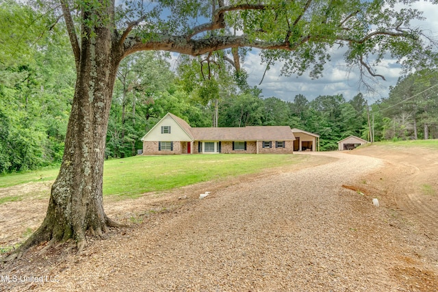 1597 Old Lake Rd, Brandon, MS 39042 - view of front facade featuring a front lawn, driveway, a forest view, and brick siding