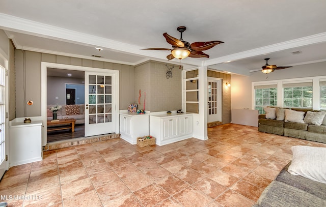 1597 Old Lake Rd, Brandon, MS 39042 - unfurnished living room with ornamental molding, a ceiling fan, french doors, and light stone finish flooring