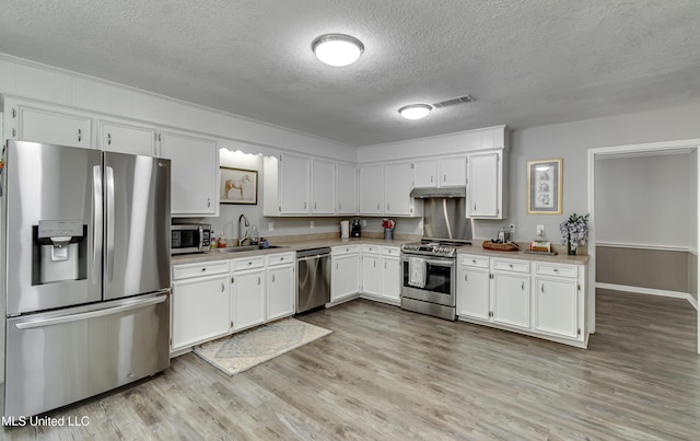 1597 Old Lake Rd, Brandon, MS 39042 - kitchen with stainless steel appliances, a sink, a textured ceiling, under cabinet range hood, and light countertops