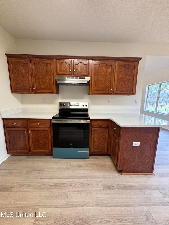 kitchen featuring light hardwood / wood-style floors, kitchen peninsula, and stainless steel range with electric cooktop