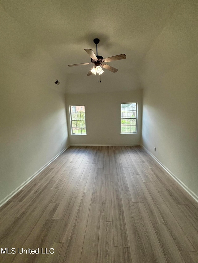 unfurnished room with a textured ceiling, ceiling fan, plenty of natural light, and light wood-type flooring