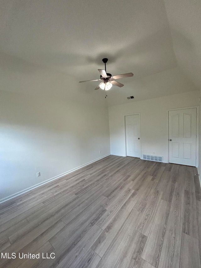 empty room featuring lofted ceiling, a textured ceiling, light hardwood / wood-style floors, and ceiling fan