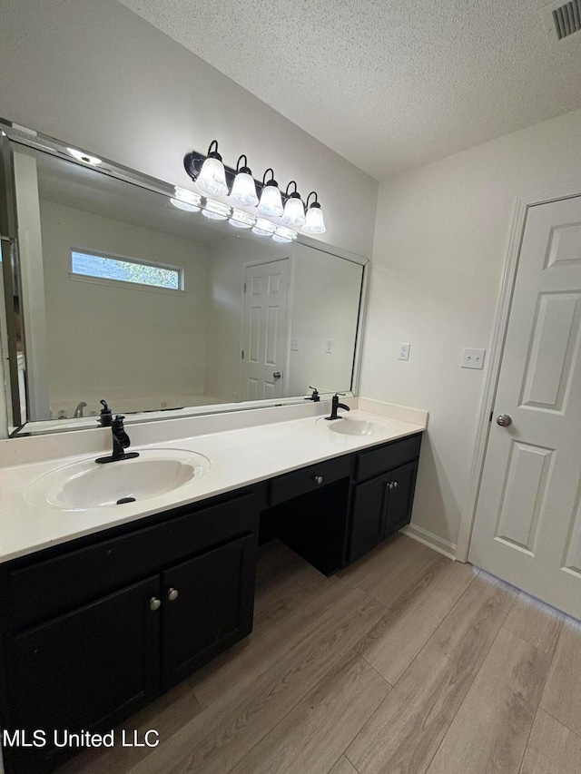 bathroom featuring vanity, hardwood / wood-style floors, and a textured ceiling