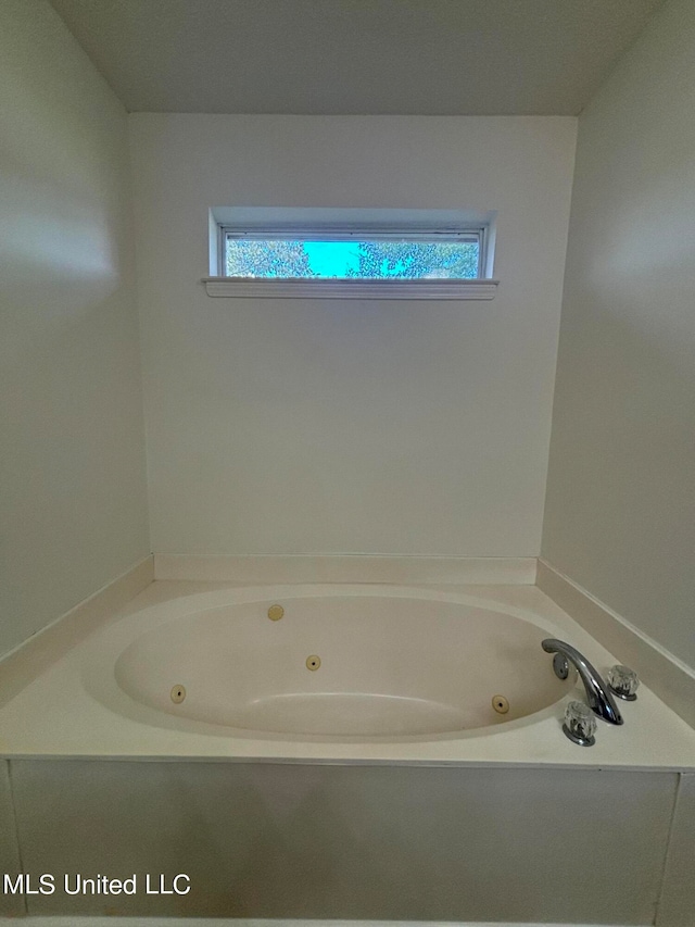 bathroom featuring a bath and a wealth of natural light