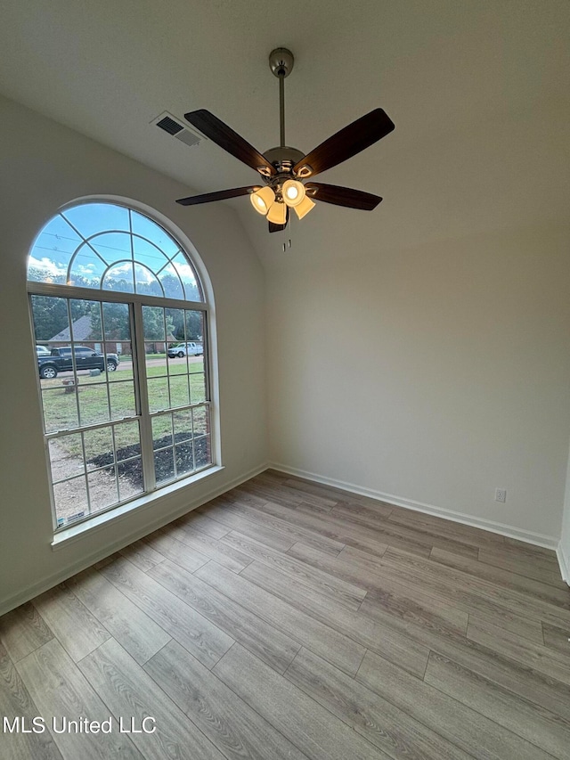 empty room with lofted ceiling, light hardwood / wood-style flooring, and ceiling fan