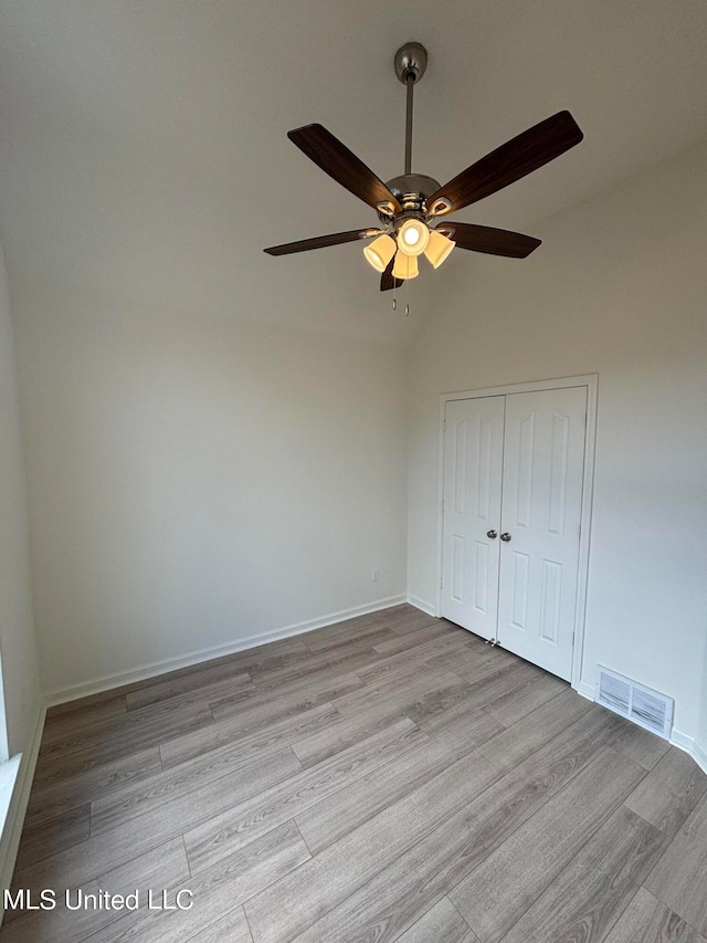 unfurnished bedroom with light hardwood / wood-style flooring, a closet, and ceiling fan