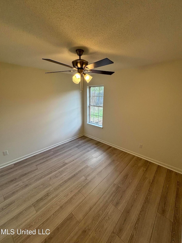 empty room with light hardwood / wood-style floors, a textured ceiling, and ceiling fan