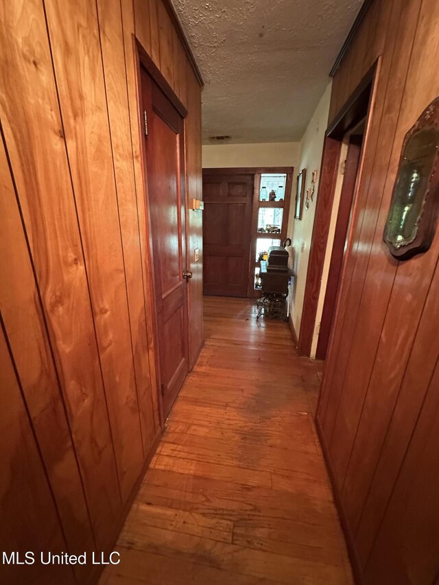 4513 Lawrence Hazel Rd, Lawrence, MS 39336 - hall featuring light wood-style floors, a textured ceiling, and wood walls