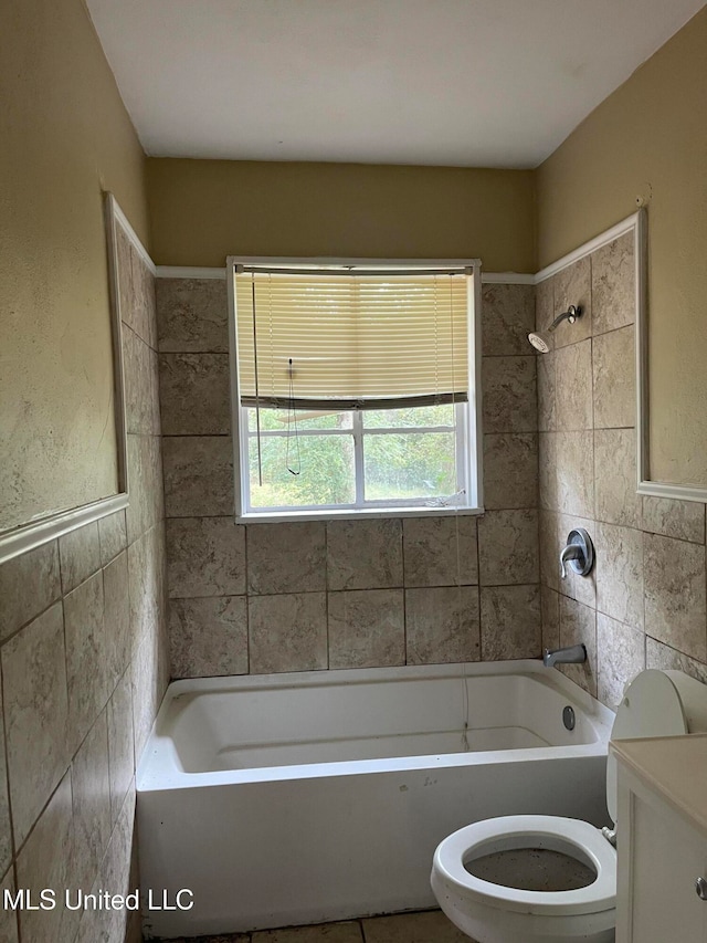 full bathroom featuring toilet, vanity, tile walls, and tiled shower / bath