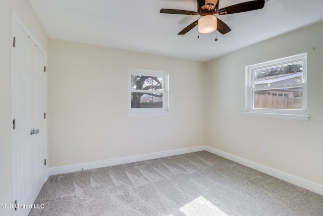 carpeted spare room with ceiling fan and a healthy amount of sunlight