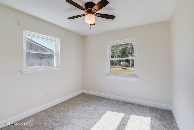 carpeted spare room with a wealth of natural light and ceiling fan