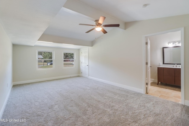 unfurnished bedroom featuring ceiling fan, ensuite bathroom, lofted ceiling, and light carpet