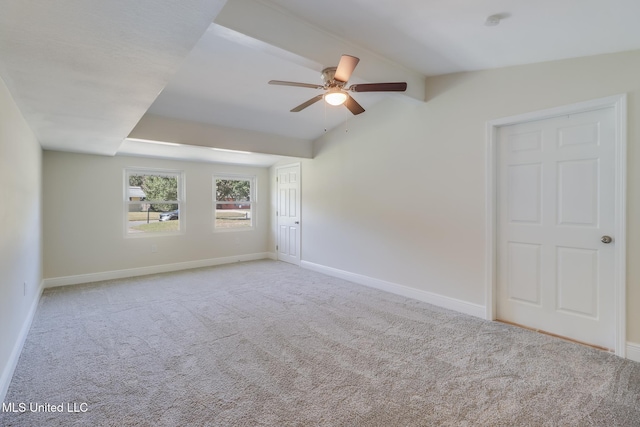 carpeted spare room featuring ceiling fan and vaulted ceiling