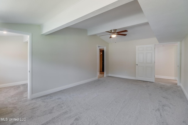 carpeted empty room featuring vaulted ceiling with beams and ceiling fan