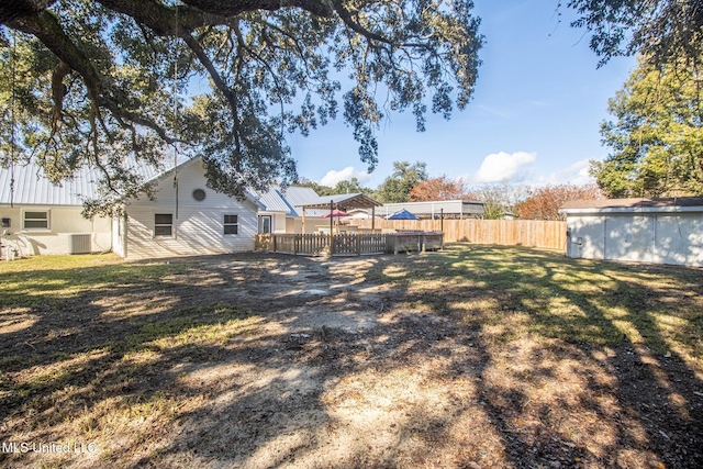 view of yard featuring central AC unit and a storage shed